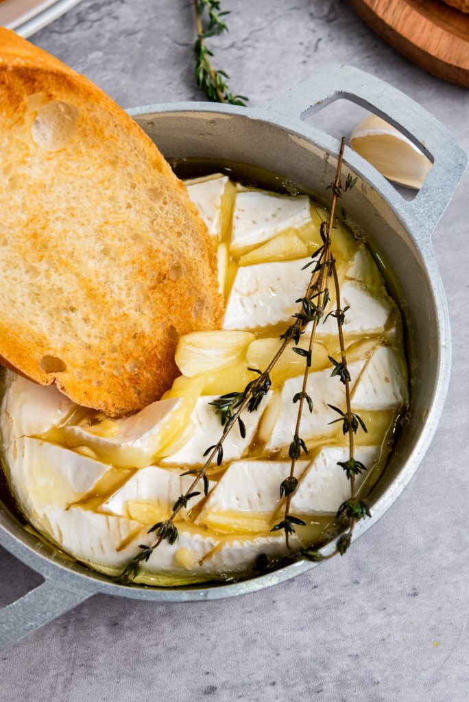 bread slice dipping into brie