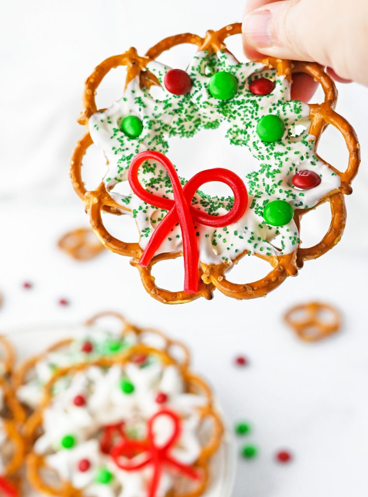 hand holding wreath made out of pretzels