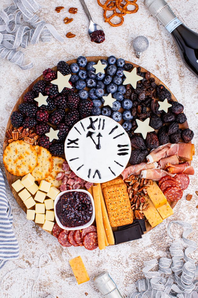 prepared charcuterie board next to Prosecco bottles